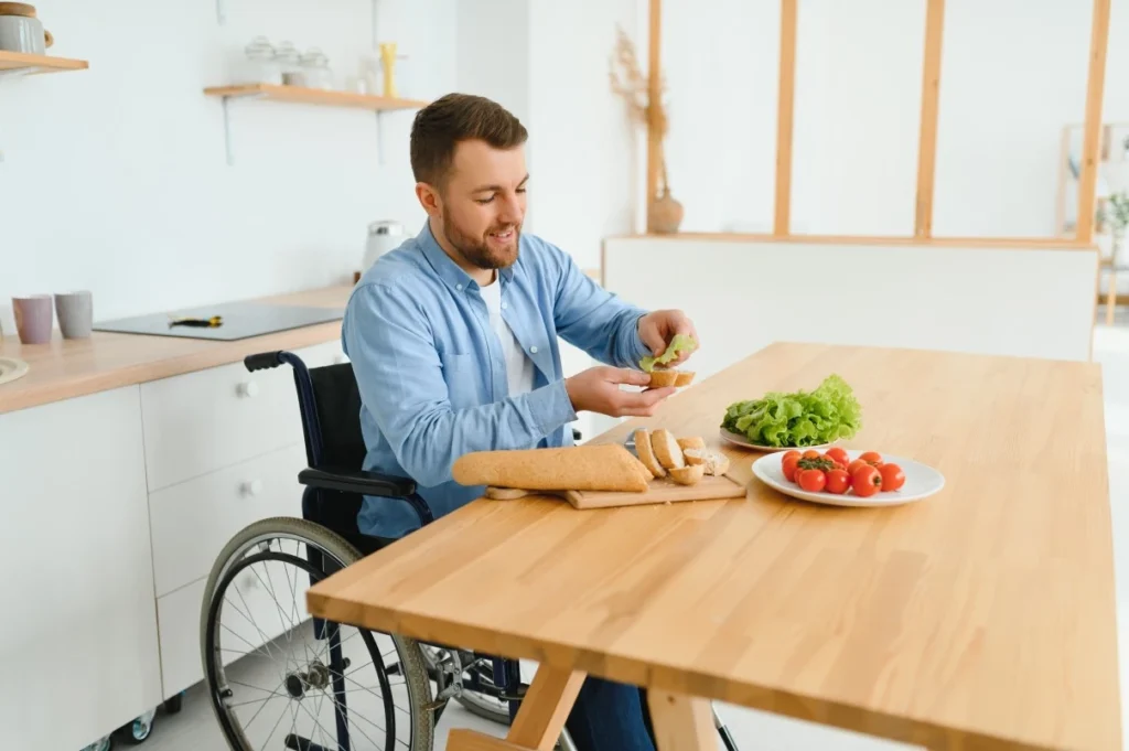 Disabled man in wheelchair sitting at kitchen table